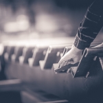 A worker's hand adjusts sheet metal at a Kootenays fabrication shop during an editorial commercial shoot, black and white.